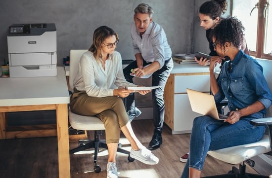 Office workers with laptops near a Xerox printer